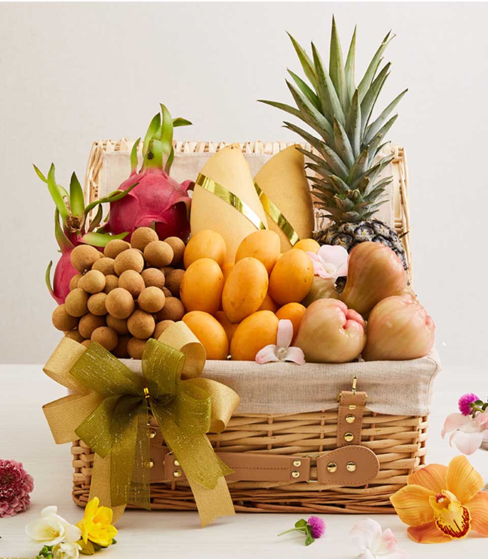 Premium wicker hamper filled with fresh Thai tropical fruits, golden mangoes, dragon fruit, and seasonal produce with gold