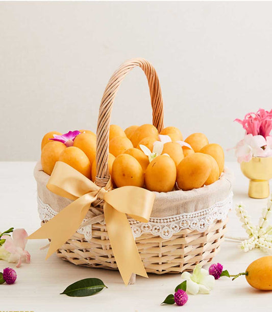 Basketeer fruit gift basket with ripe Marian plums, accented with orchids. A premium hamper delivery in Thailand for any occasion.