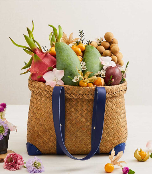 Tropical fruit harvest woven straw tote with dragon fruit, mangoes, kumquats, longans, passion fruit and orchids