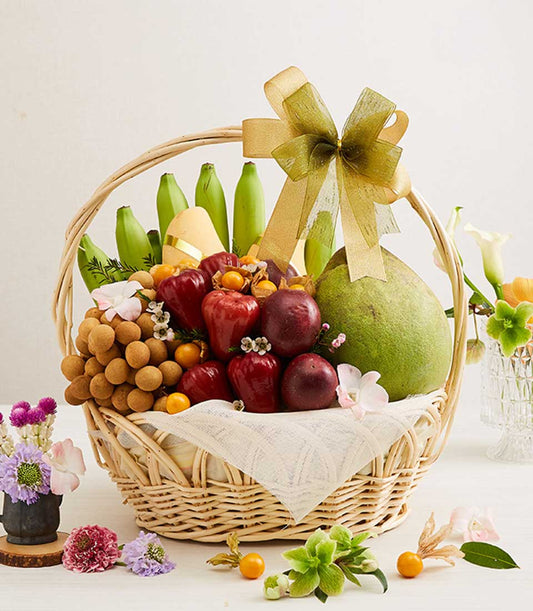 Light brown wicker basket filled with Thai tropical fruits, mangoes, rose apples, longans, and fresh orchids with