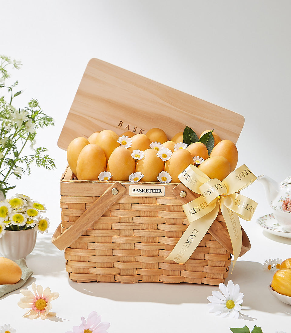 Golden mango luxury gift basket with fresh flowers and woven picnic hamper for premium Thai gifting