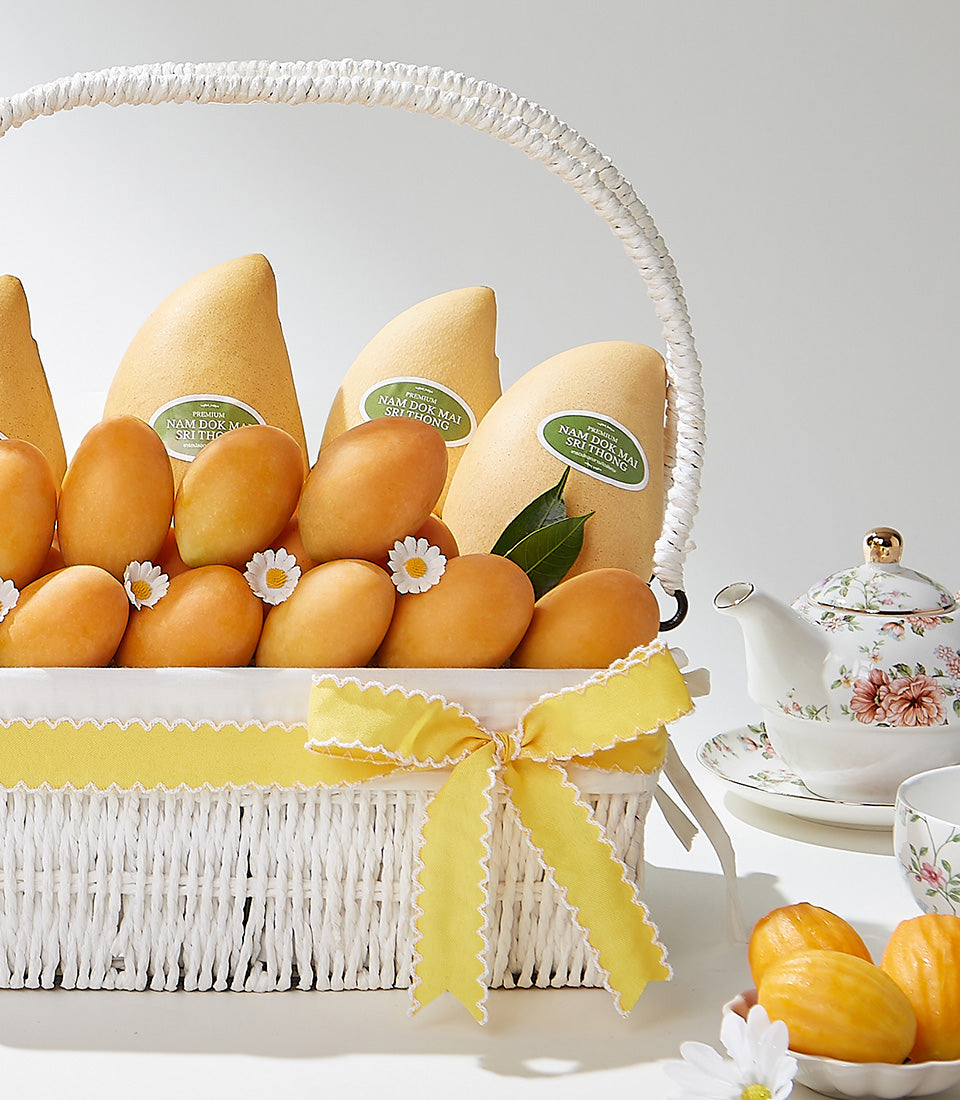 Luxury mango gift basket with Nam Dok Mai Sri Thong mangoes, ceramic teapot, and golden pastries tied with yellow ribbon