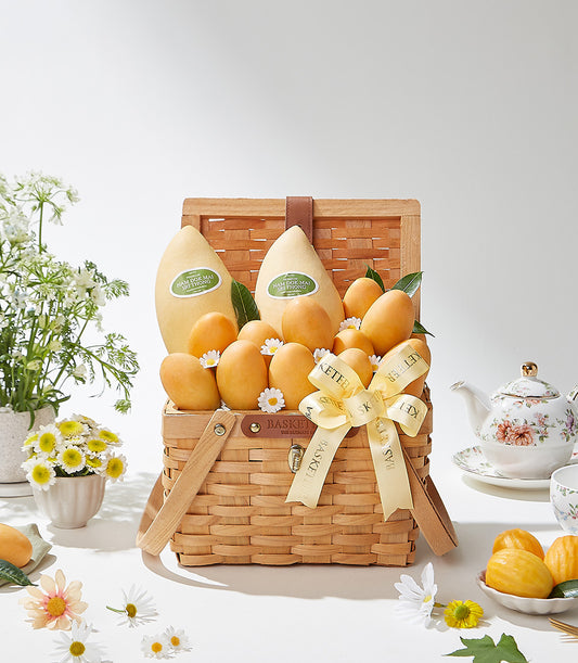 Premium Mayongchid and Thai mango gift basket with woven leather handles, fresh yellow mangoes, white daisies, and artisan