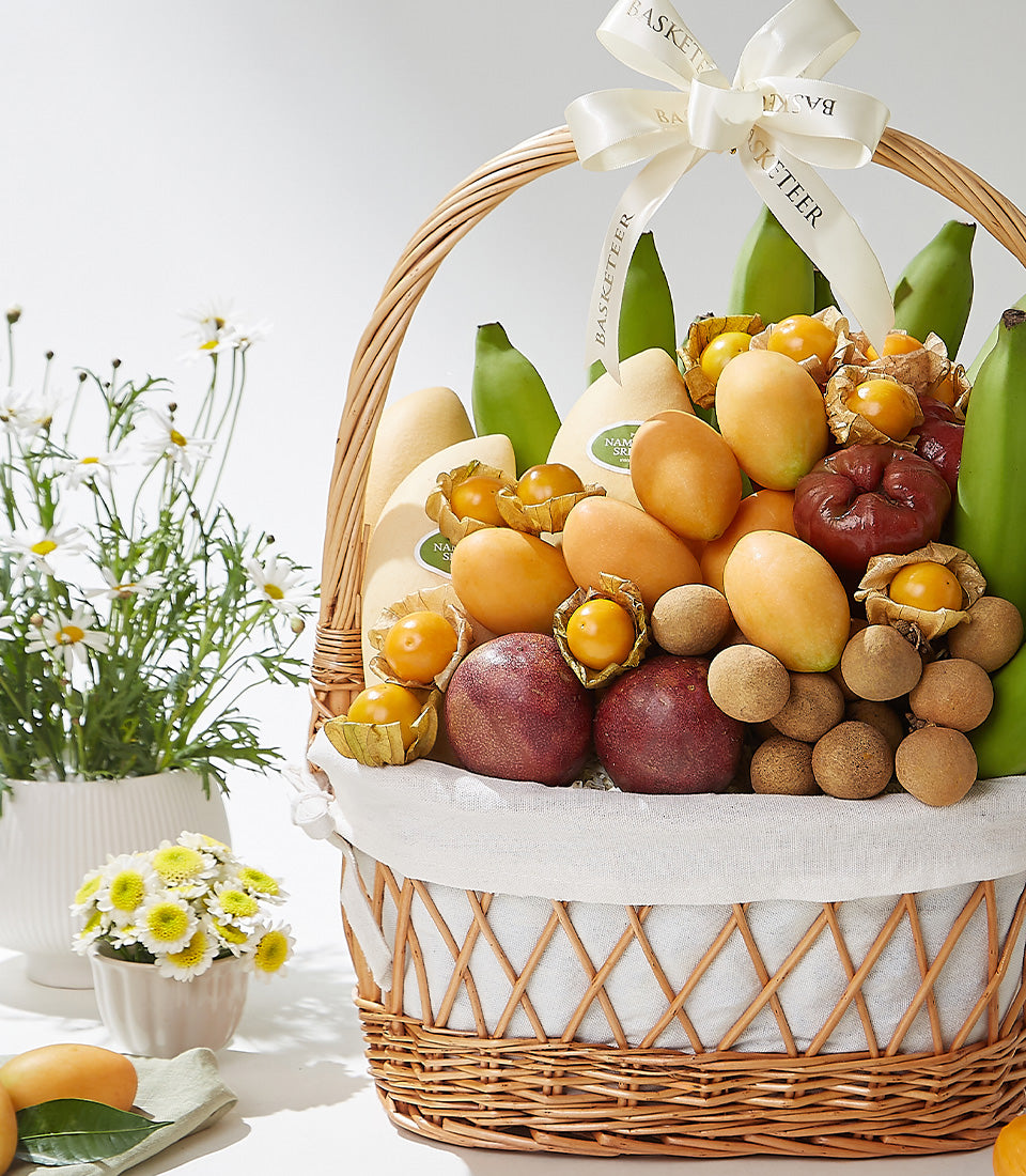 Premium tropical fruit gift basket with mangoes, passion fruits, and longans in wicker with cream ribbon