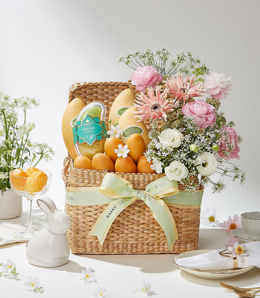 Premium Thai fruit and flower gift basket with mangoes, tropical blooms, and sticky rice in woven straw