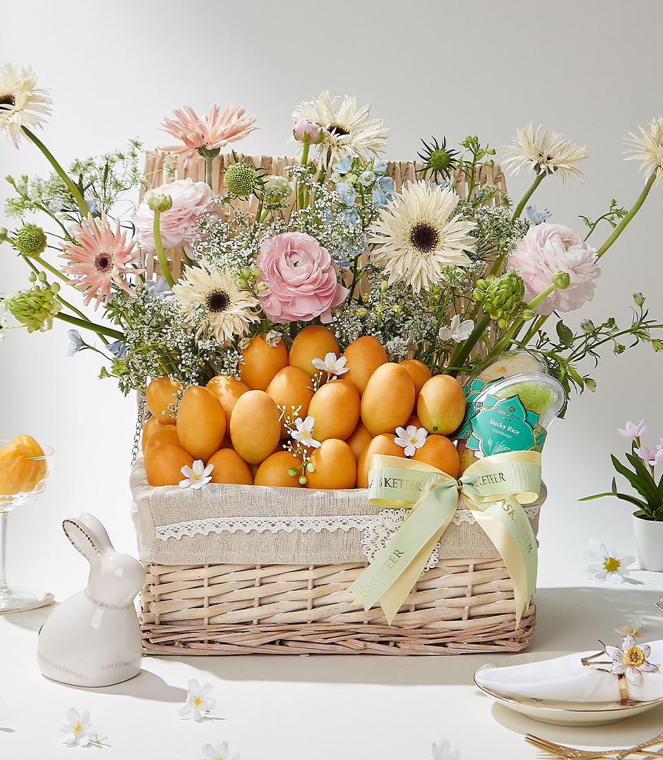 Deluxe wicker basket overflowing with Thai mangoes, fresh flowers, and artisan sticky rice gift set