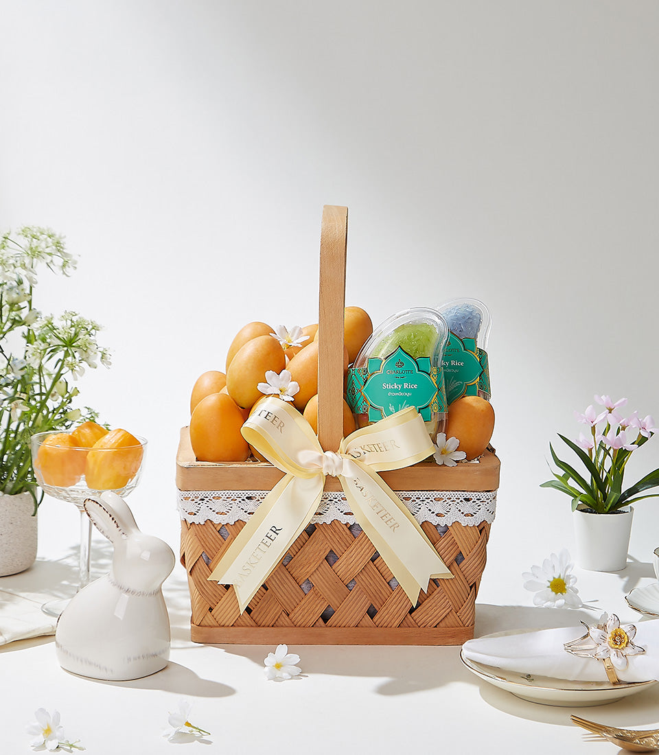 Golden Bliss woven basket filled with Thai golden mangoes, sticky rice, and white spring flowers