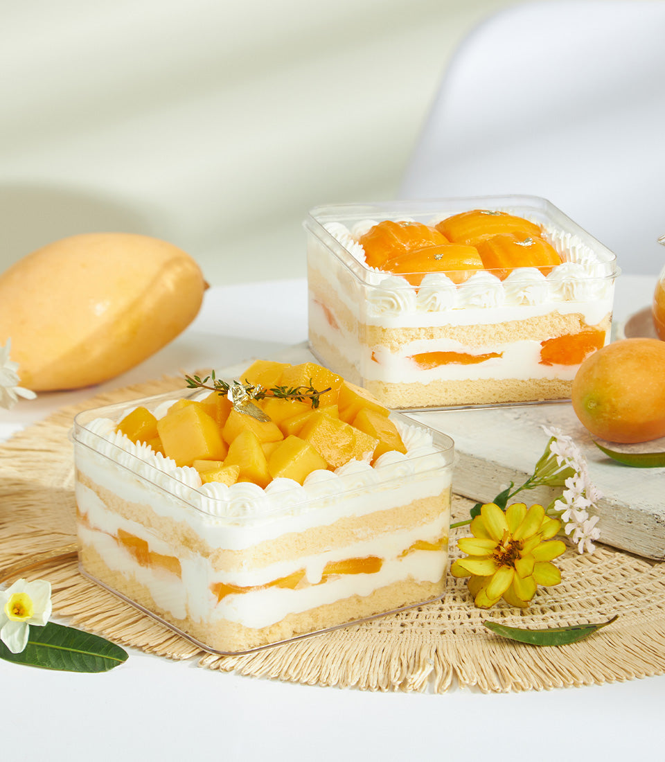 Mini summer soft fresh cream cake with mango, whipped cream layers, and tropical fruit garnish