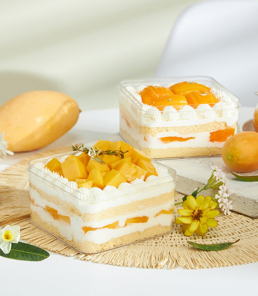 Mini summer soft fresh cream cake with mango, whipped cream layers, and tropical fruit garnish