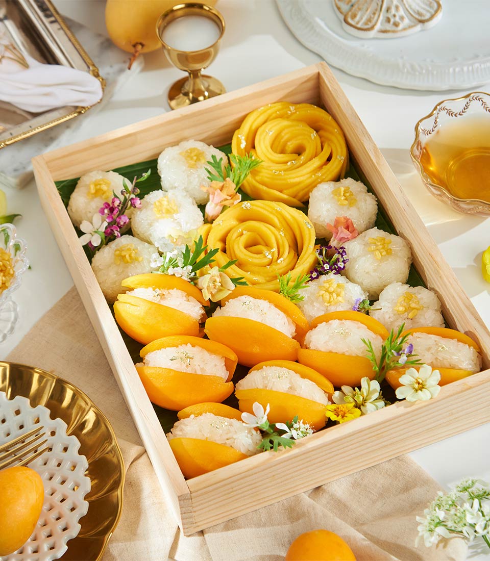 Luxury mango and sticky rice gift box with gold leaf accents and fresh flowers