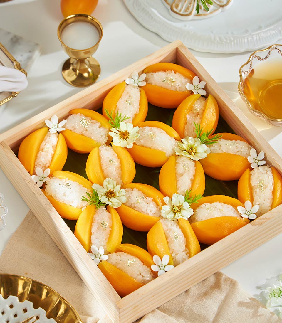 Premium mango sticky rice with gold leaf in wooden tray, artisan Thai tropical dessert gift