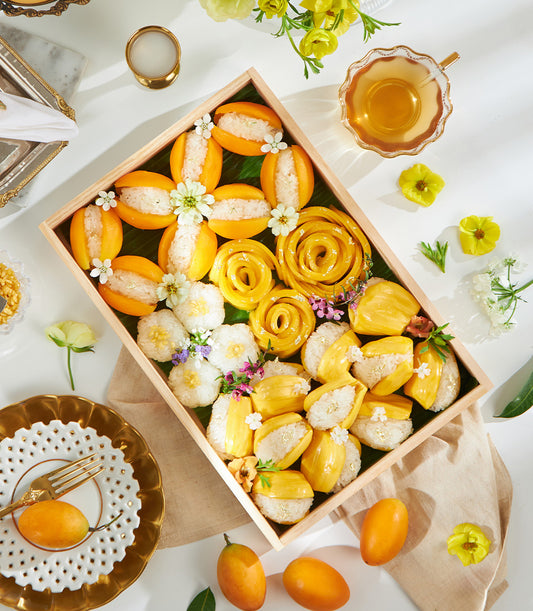 Premium Thai mango sticky rice gift box with carved fruit roses, jackfruit, edible gold, and fresh flowers