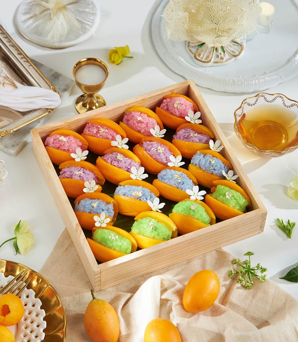 Royal Rainbow mango sticky rice dessert box with pink, purple, and blue servings in fresh mango halves, topped with edible