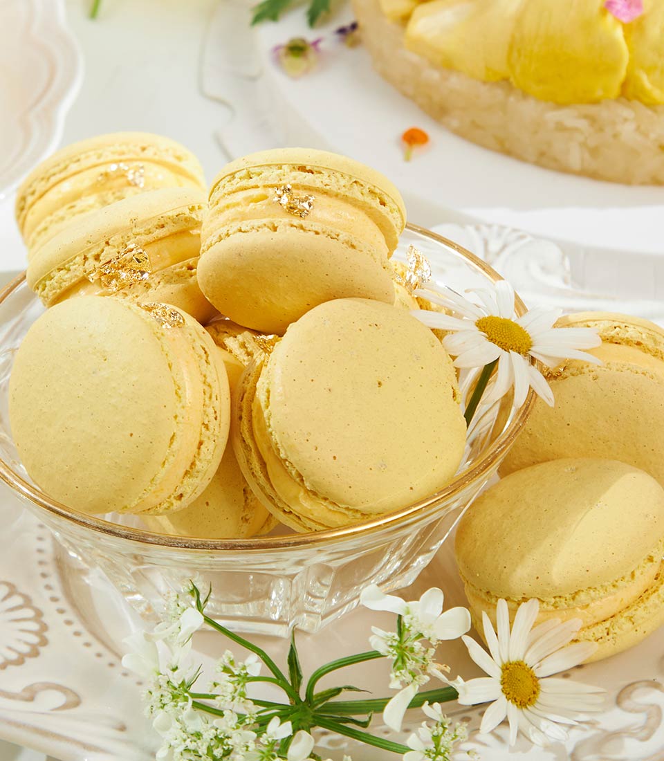 Golden mango macarons with edible gold leaf in luxury gift box