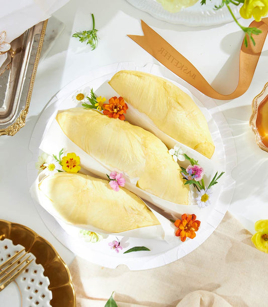 Premium Rayong Mon Thong durian pods on ruffled plate with fresh flowers and luxury presentation