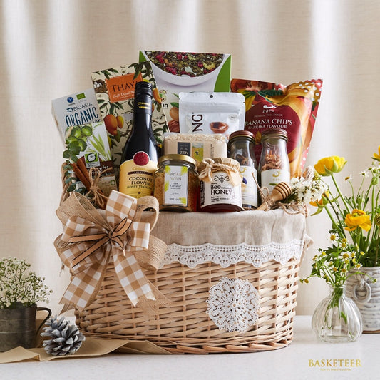 Wicker gift basket with gourmet honey, coconut products, and artisan treats tied with burlap bow