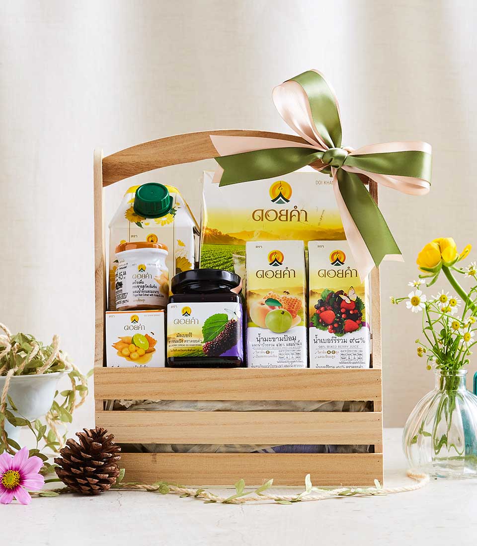 Wooden crate gift basket with Doi Kham preserves, juices, and jams tied with pink and olive ribbons
