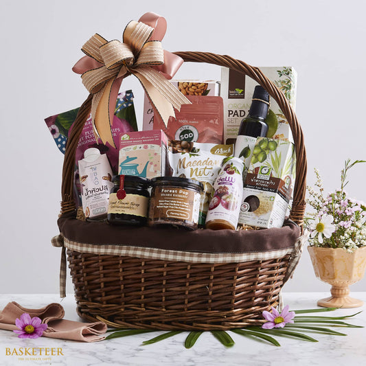 Premium Thai gourmet gift basket with organic coffee, coconut syrup, and artisan foods in dark wicker with peach bow