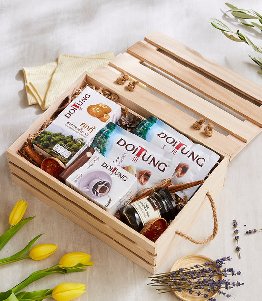 Light wood gift crate filled with Doitung macadamia nuts, drip coffee, honey, and artisan cookies with rope handle