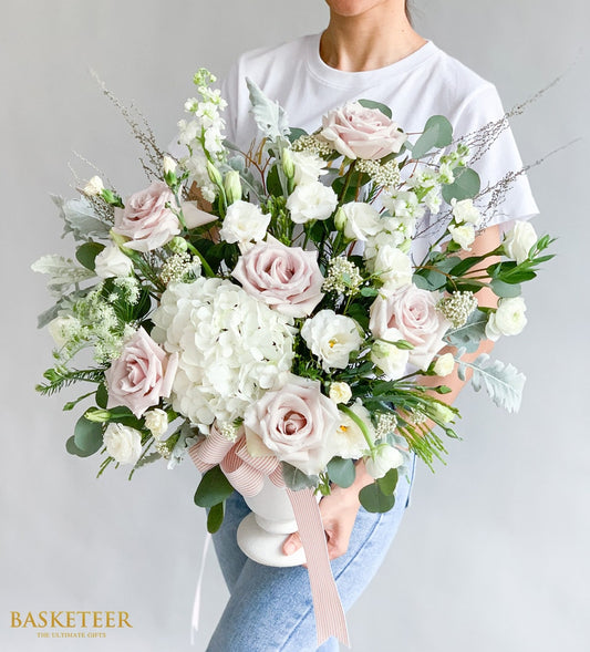 Elegant flower delivery Bangkok: Flowers by Basketeer vase arrangement with blush roses, white hydrangea and lisianthus. Finished with a delicate pink ribbon.