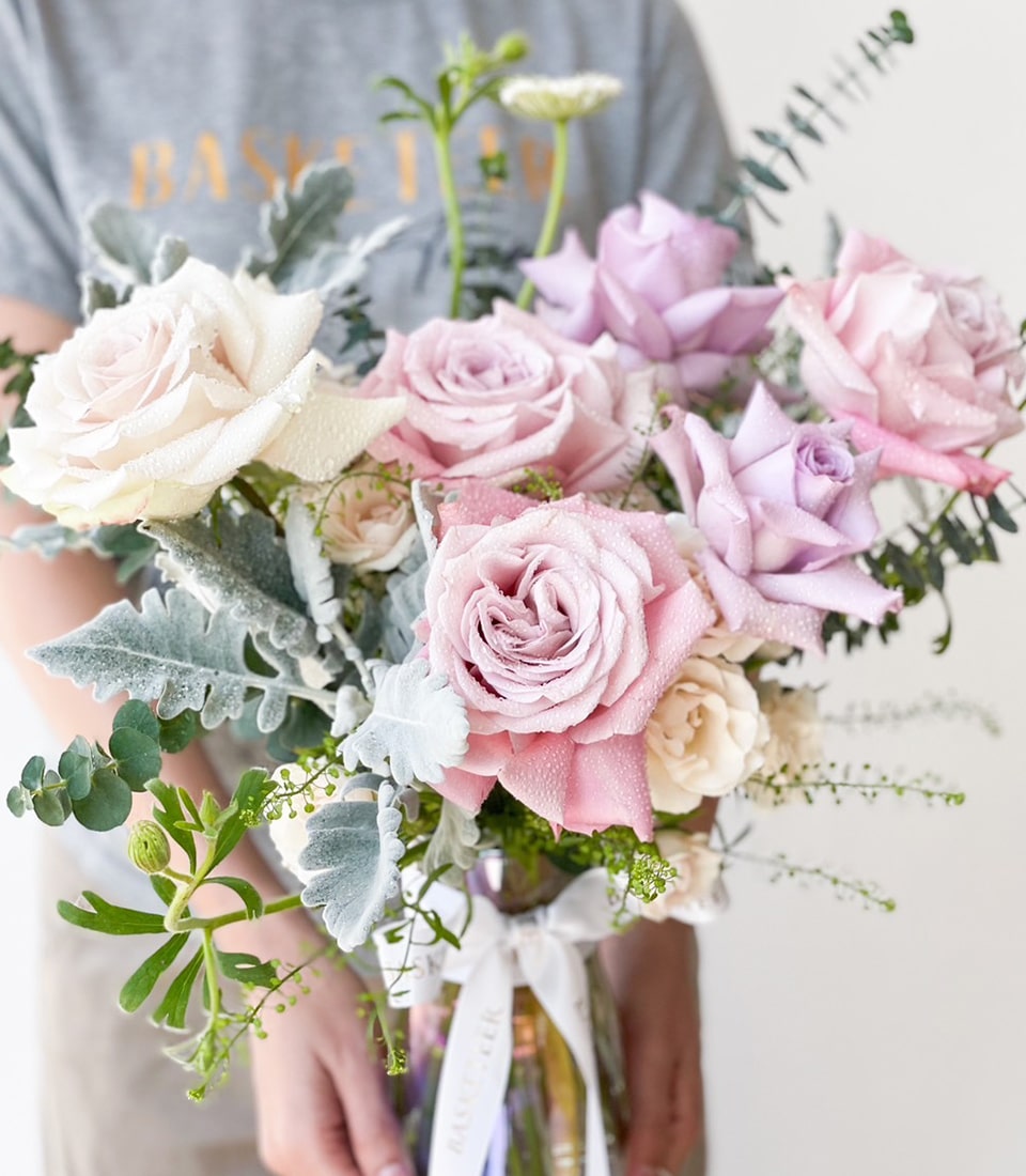 Fresh lavender and pink rose bouquet with eucalyptus and dusty miller in glass vase