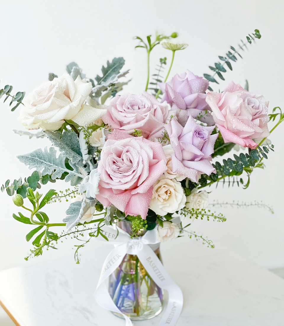 Fresh lavender and white rose bouquet with eucalyptus in clear glass vase