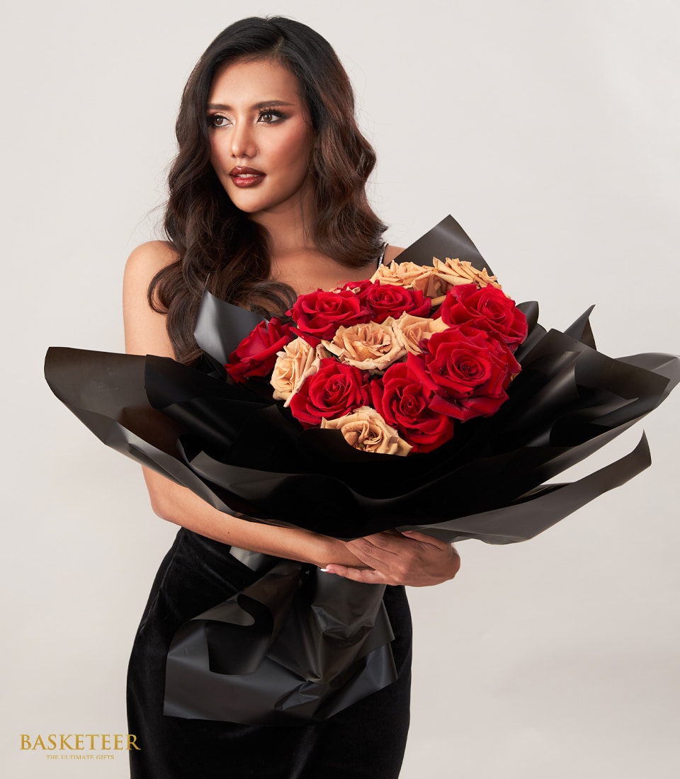 Woman holding luxury red and beige rose bouquet wrapped in black paper for anniversary