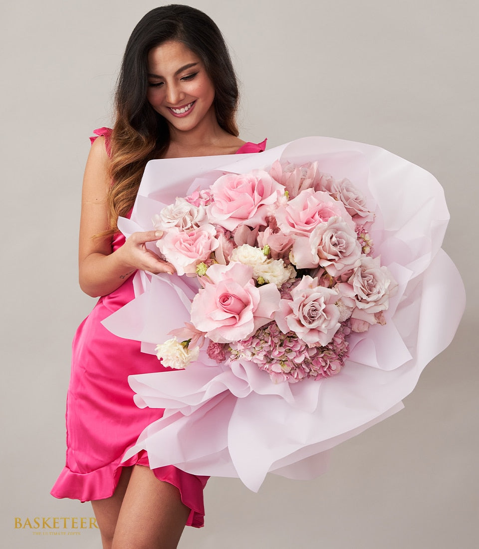 Blush pink and dusty rose bouquet with white filler flowers and hydrangeas, wrapped in tissue paper