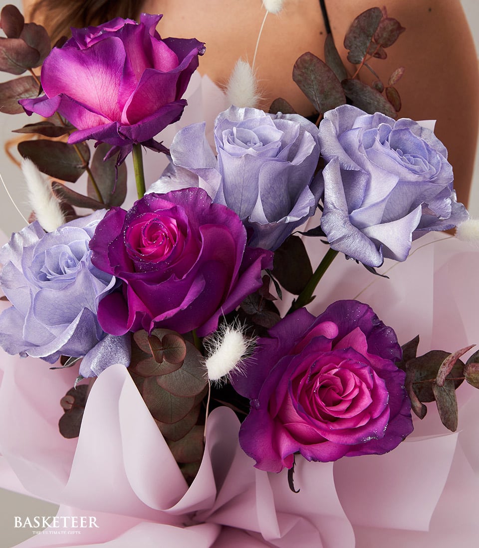 Purple and lavender rose bouquet with eucalyptus, wrapped in light pink paper