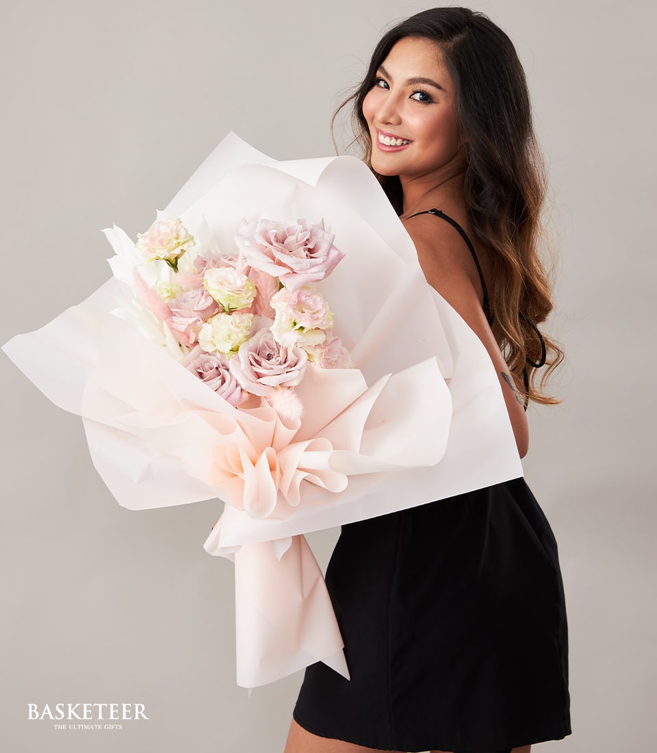 Blush Serenity pink and cream rose bouquet with light pink accents, wrapped in layered pink paper with ruffled ribbon bow