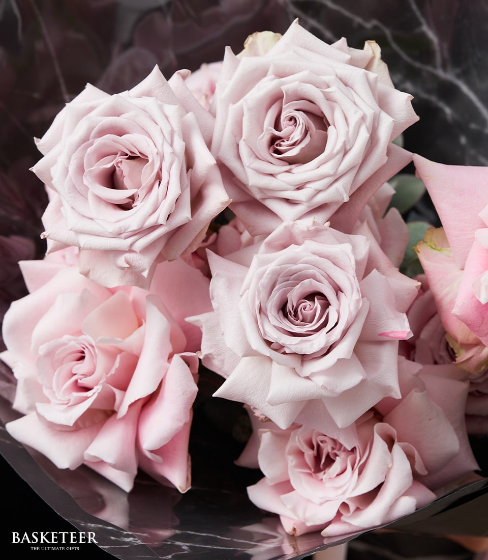 Soft pink and lavender rose bouquet with elegant dark wrap, perfect Valentine's gift for her