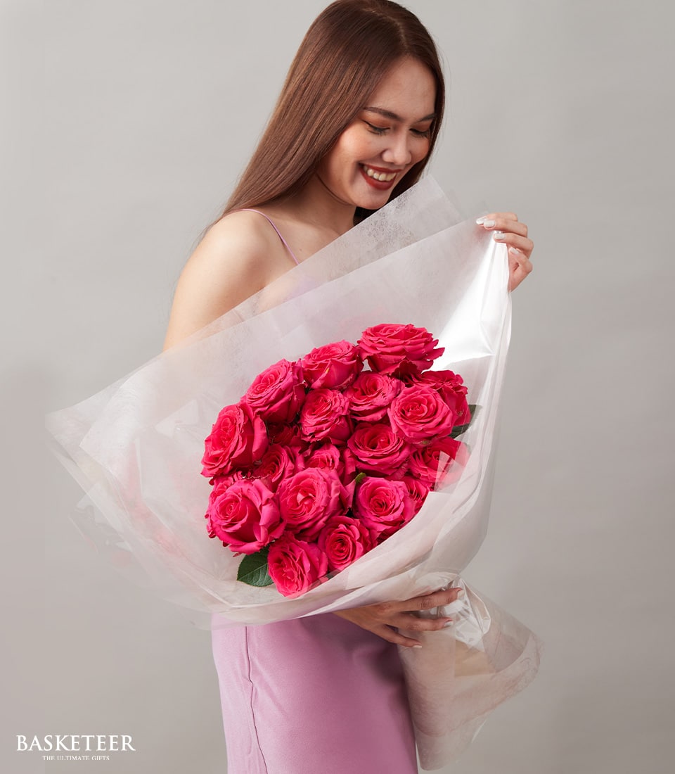 Vivid hot pink rose bouquet wrapped in white cellophane, perfect for anniversaries and celebrations