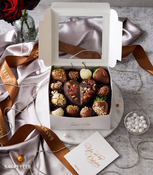 Luxury chocolate-covered strawberries and heart-shaped chocolate in white gift box with satin ribbon