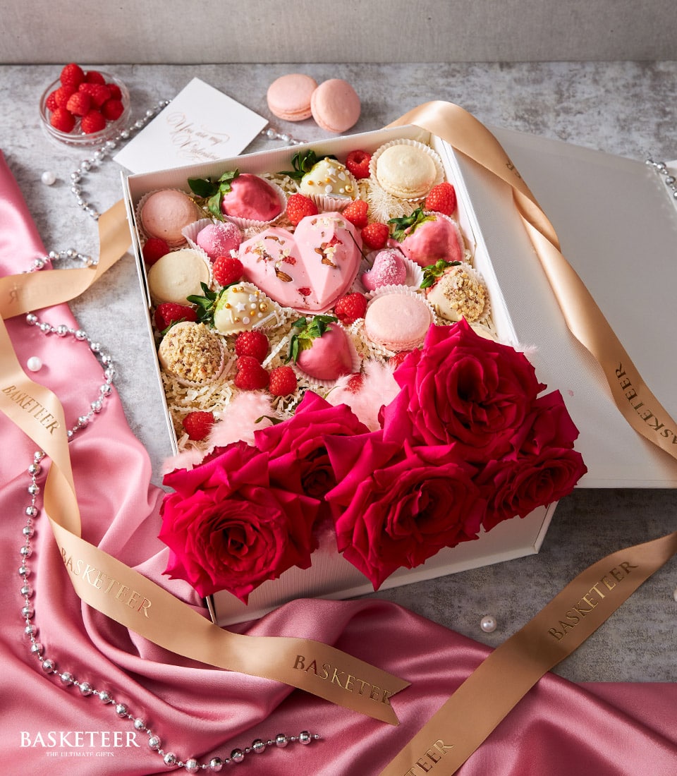 Deluxe pink heart chocolate box with strawberries, macarons, and fresh red roses for anniversary