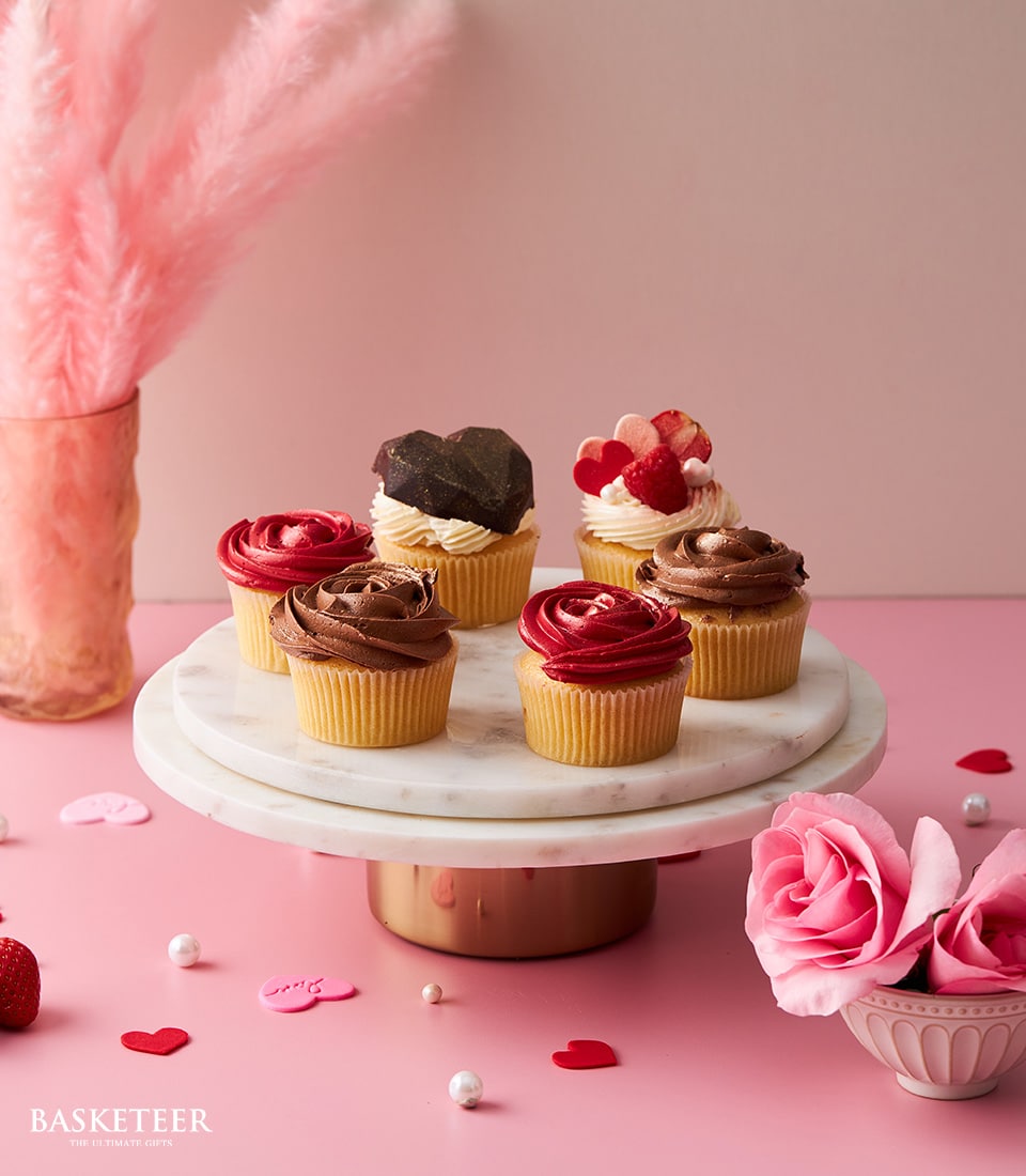 Vanilla buttercream cupcakes with rose and heart decorations on marble stand, Valentine's Day gift
