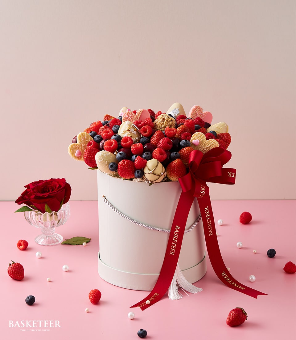 Luxury berry gift box with chocolate-dipped strawberries and hearts, tied with red ribbon for Valentine's Day