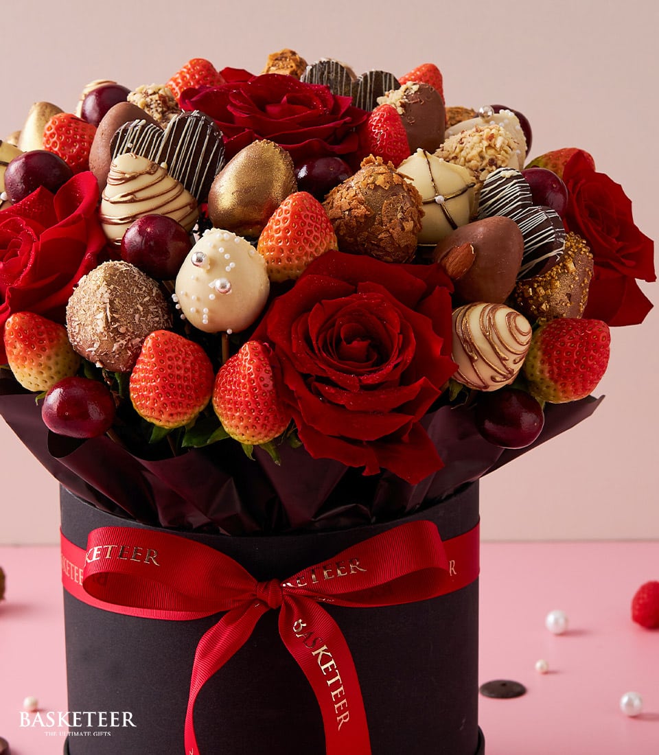 Red roses and chocolate-dipped strawberries in luxury black gift box for Valentine's Day