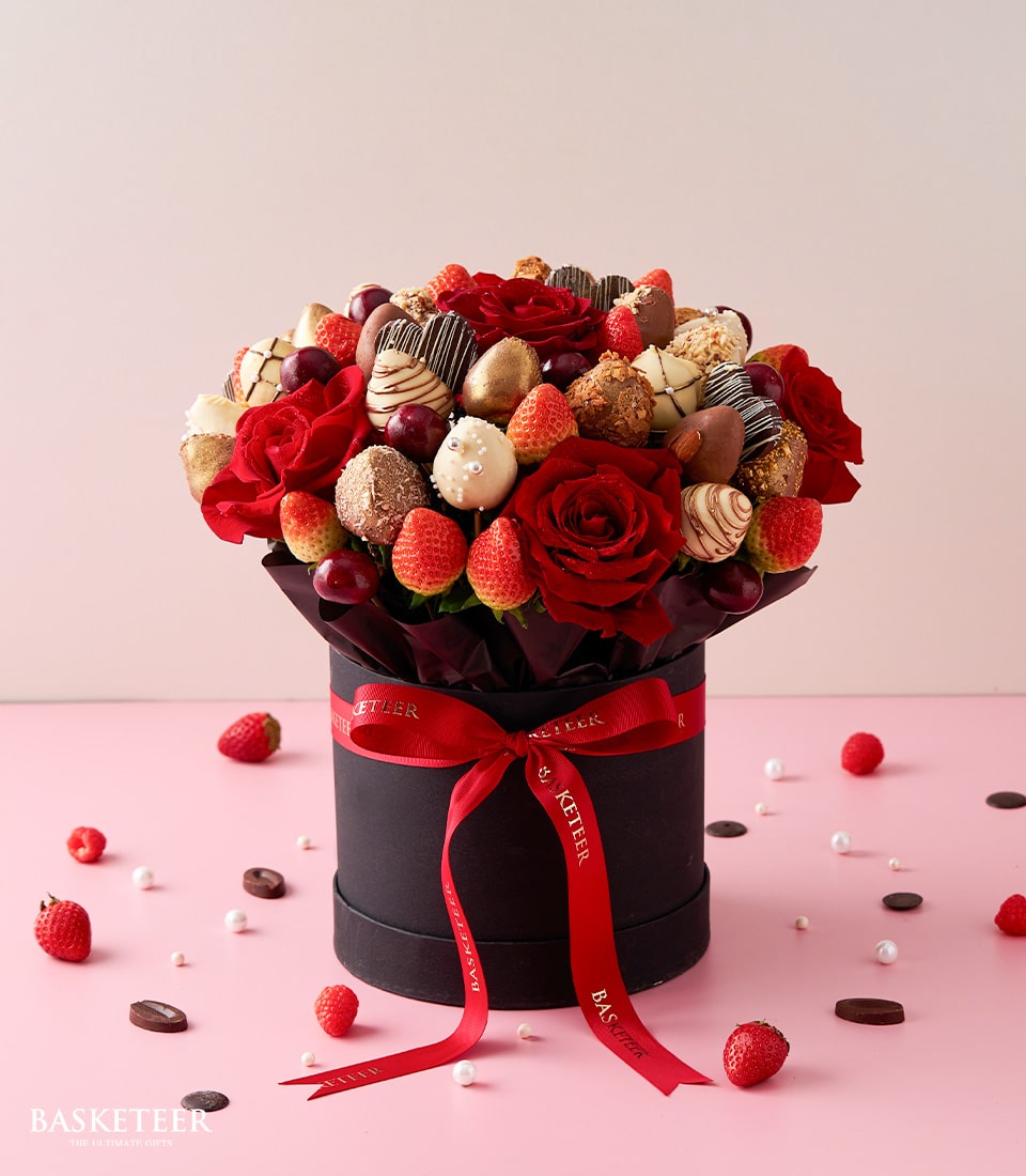 Luxury Valentine's edible bouquet with fresh red roses, chocolate-dipped strawberries, and dark cherries in black gift box