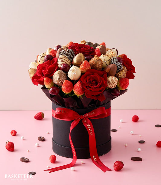 Luxury Valentine's edible bouquet with fresh red roses, chocolate-dipped strawberries, and dark cherries in black gift box