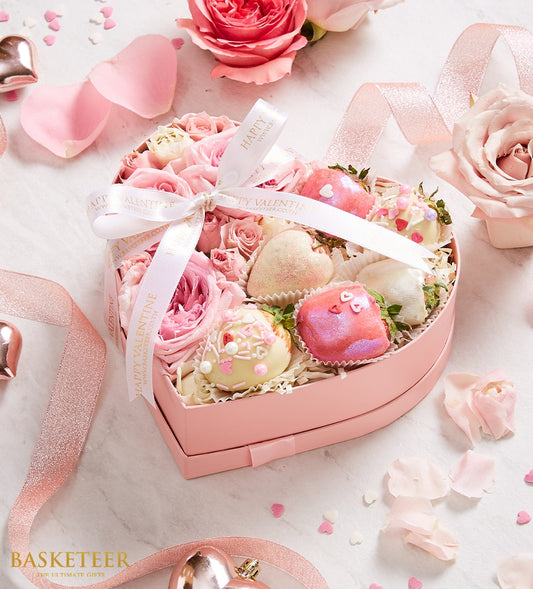 Heart-shaped gift box with pink roses and assorted chocolate-covered strawberries in white, pink, and gold coatings