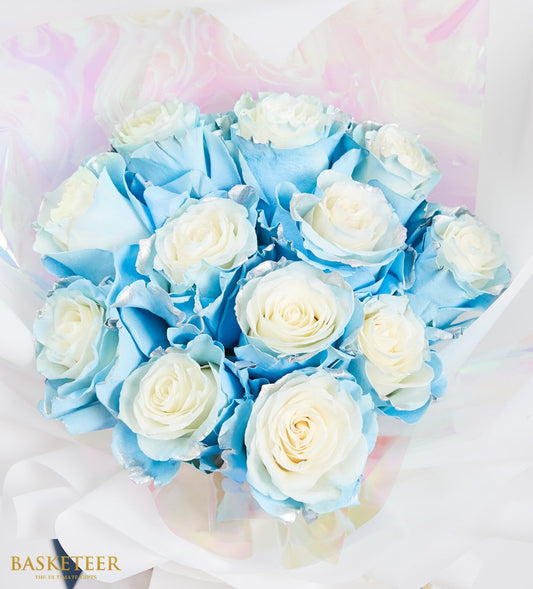 Ethereal blue and white rose bouquet with frosted petals, wrapped in iridescent paper with white satin ribbon