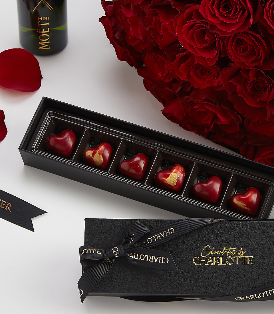 Luxe Valentine gift set with deep red roses, heart-shaped chocolates, and Moët champagne