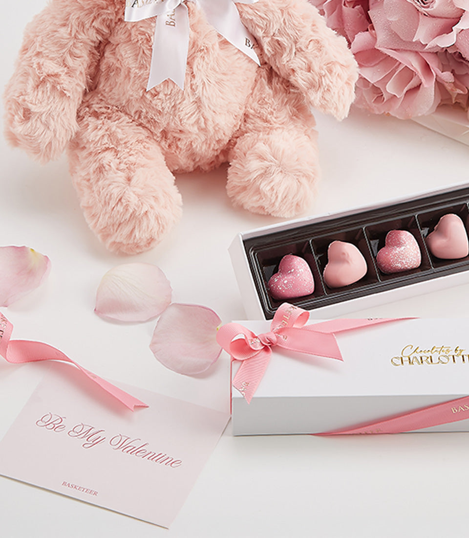 Luxury Valentine's rose and chocolate gift set with pink teddy bear, heart-shaped chocolates, and fresh rose petals