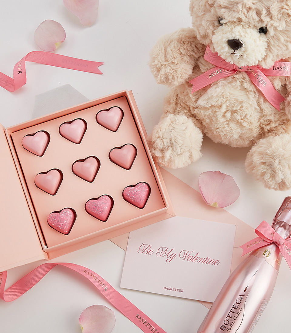 Rosé sparkling wine gift set with heart-shaped chocolates, teddy bear, and Valentine's Day card