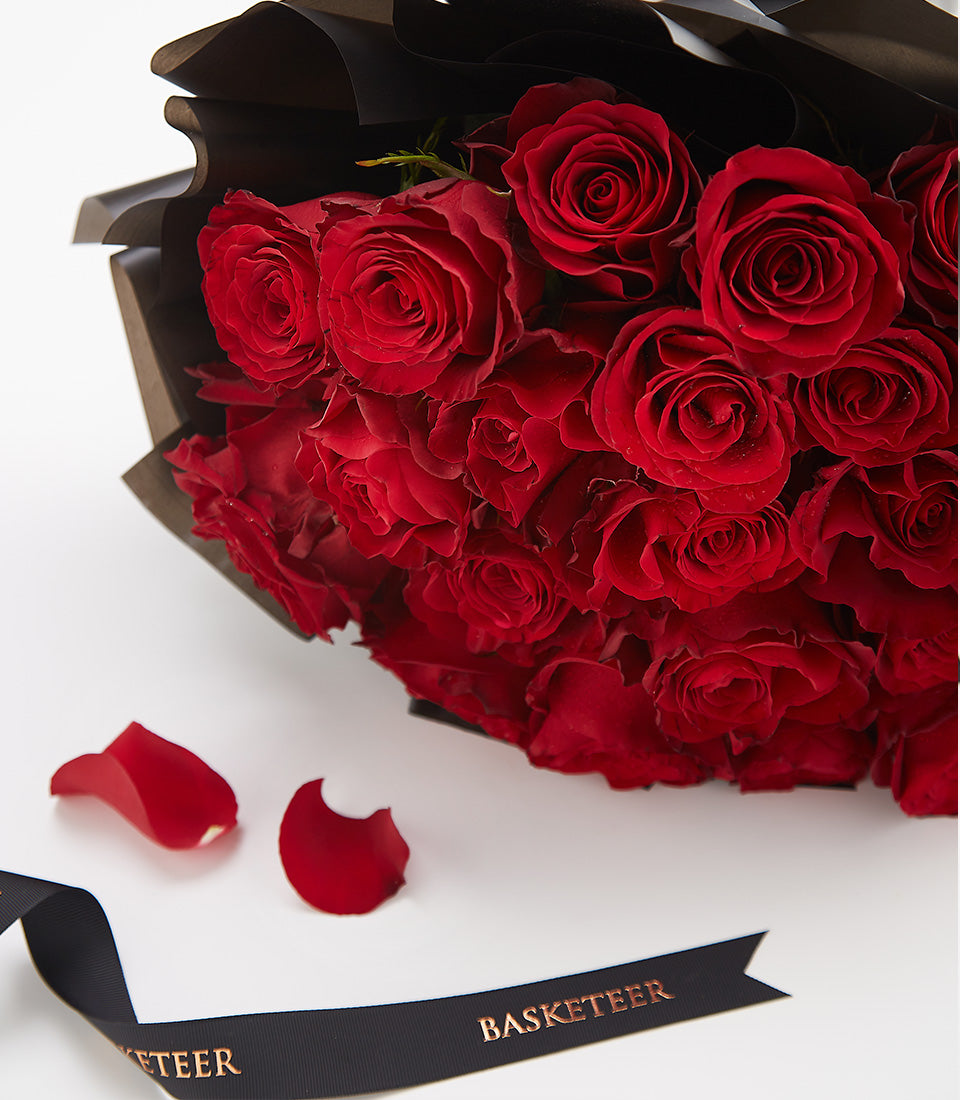 Premium red rose Valentine's bouquet with black wrapping and gold ribbon detail