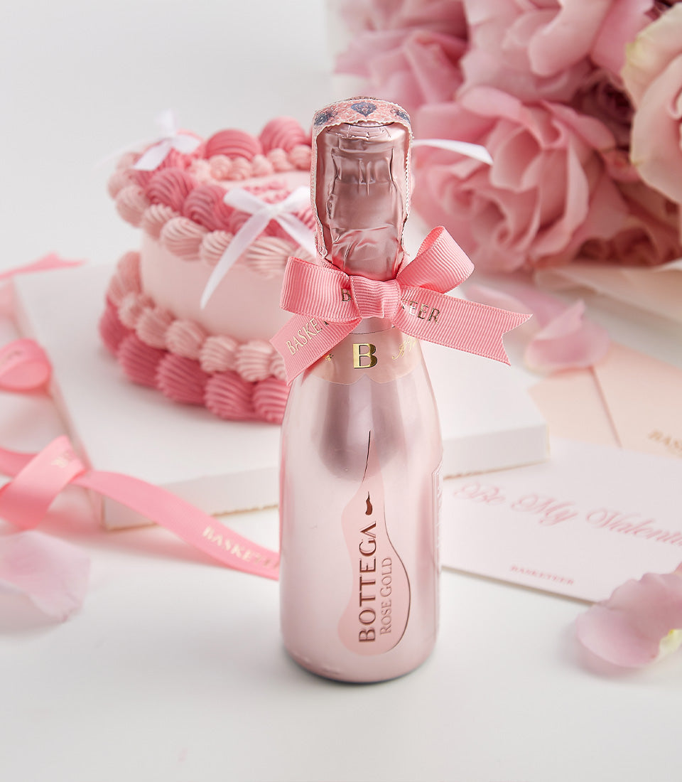 Romantic pink Valentine's wine gift set with sparkling wine, two-tier cake, Ecuador roses, and rose petals