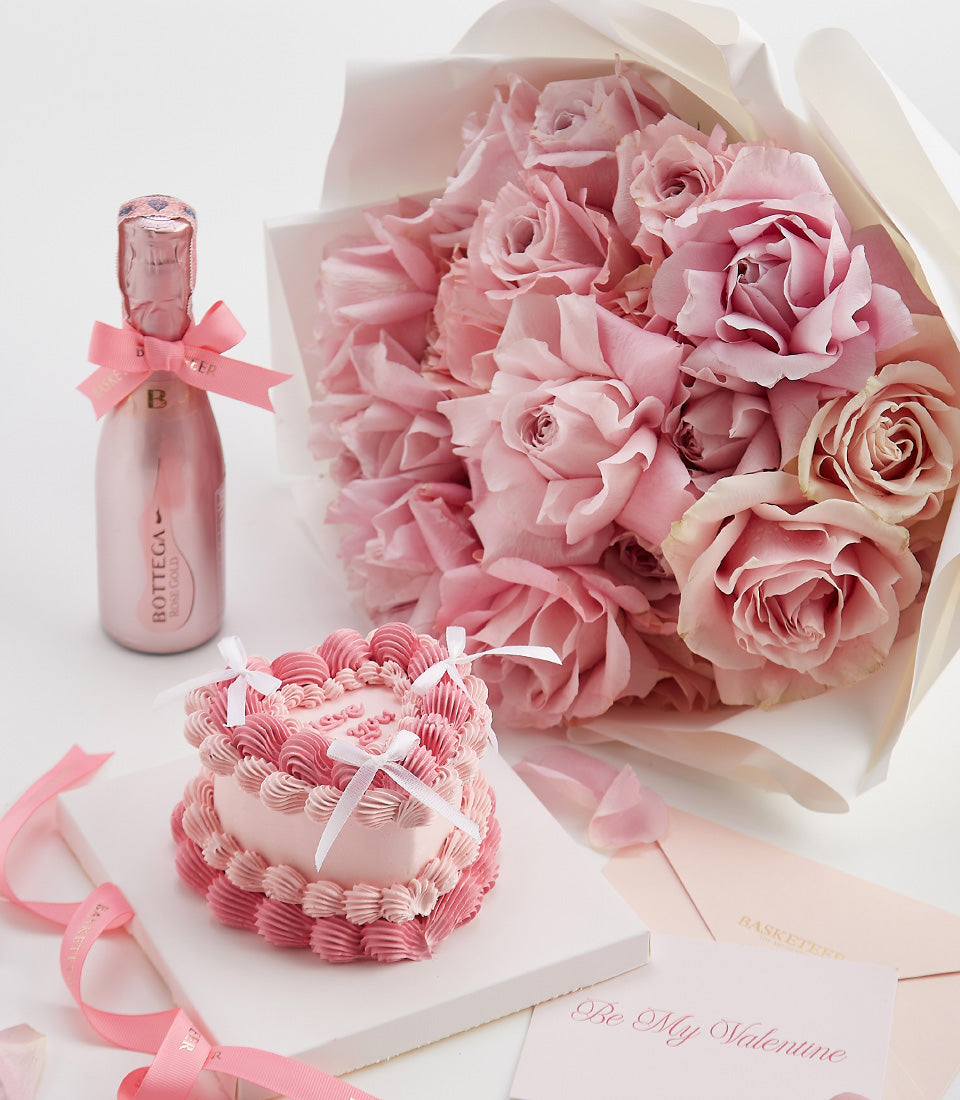 Romantic pink Valentine's gift set with Bottega Rose Gold sparkling wine, fresh roses, and heart-shaped cake with white