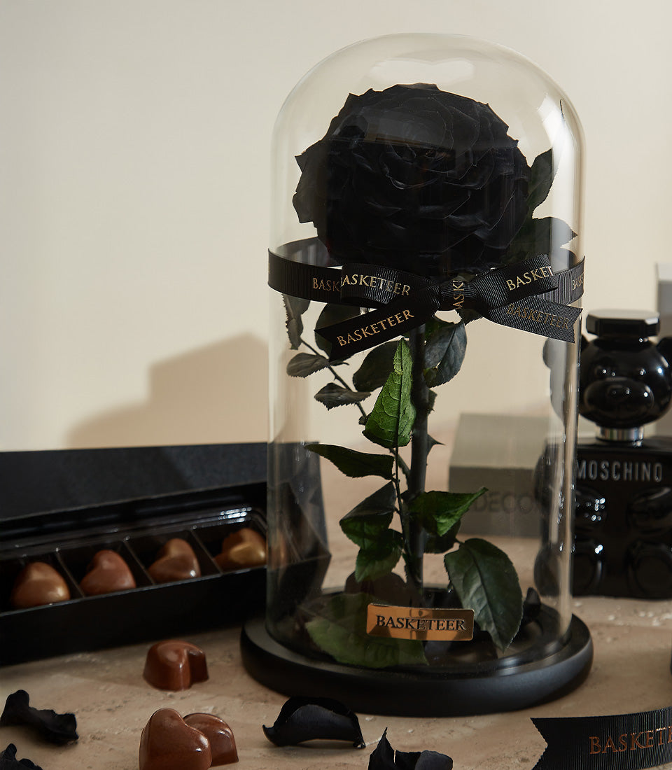 Luxury Valentine gift set with preserved black rose in glass cloche, heart-shaped chocolates, and Moschino teddy bear bottle