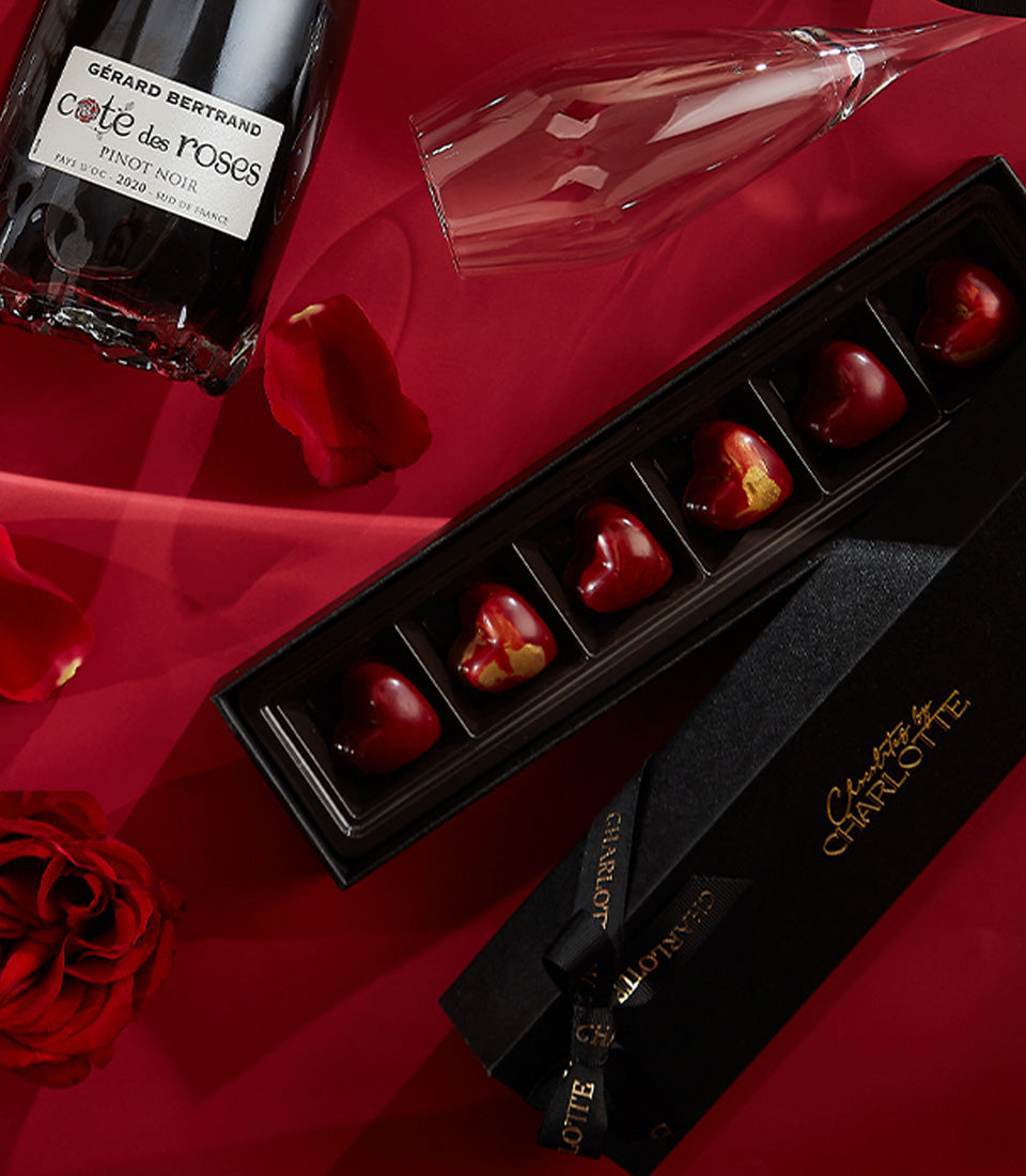 Luxury red rose Valentine's gift set with Pinot Noir wine, heart-shaped chocolates, and fresh roses on silk