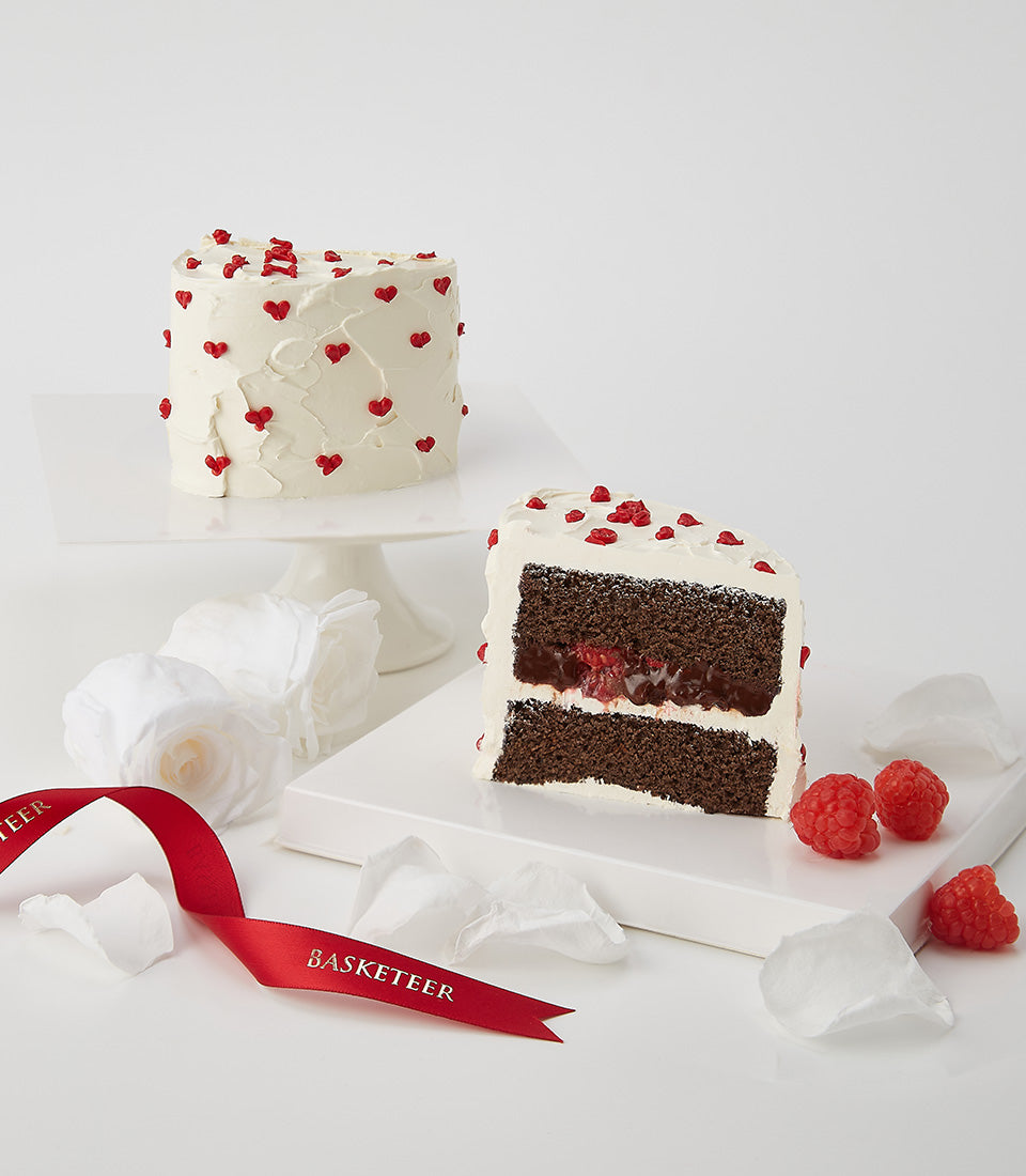 Dark chocolate and raspberry layer cake with white frosting and red hearts, Valentine's dessert gift